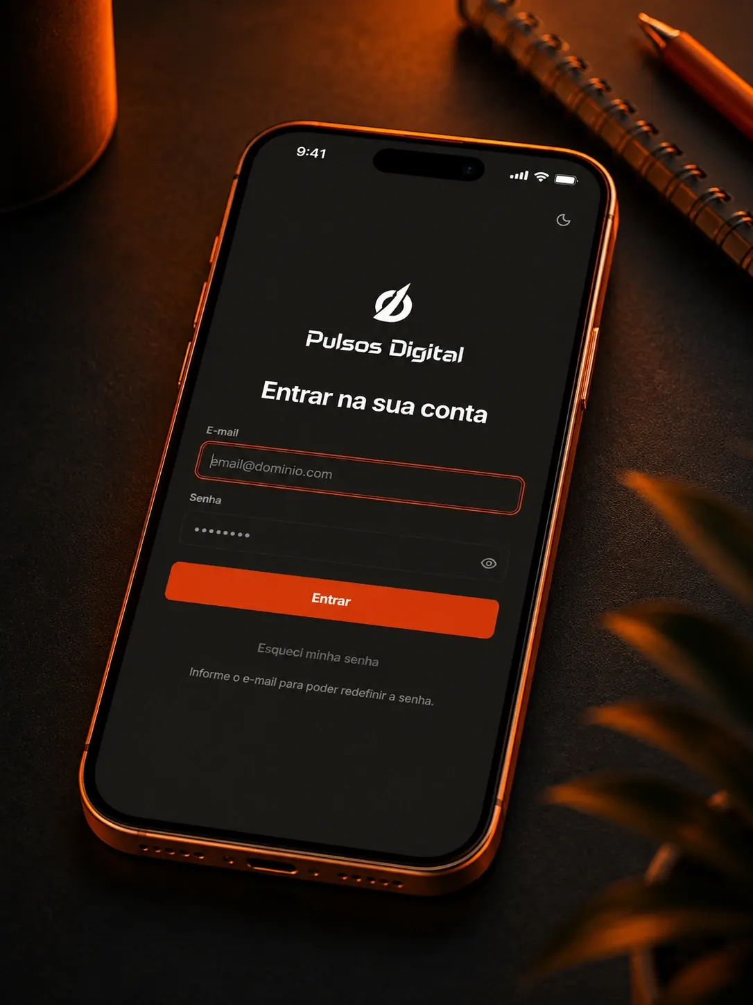 Tela de login do Pulsos Digital em um celular apoiado sobre a mesa de trabalho